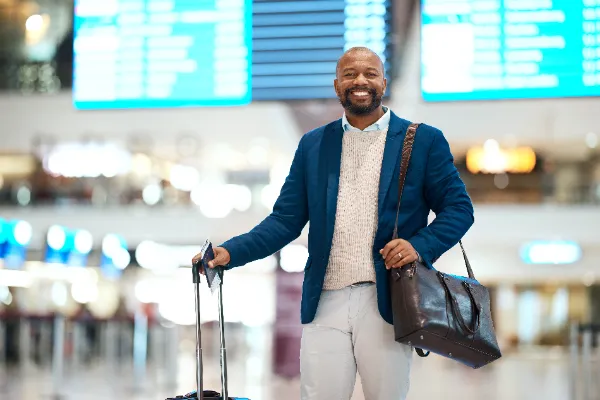 portrait of a black man at the airport with luggage